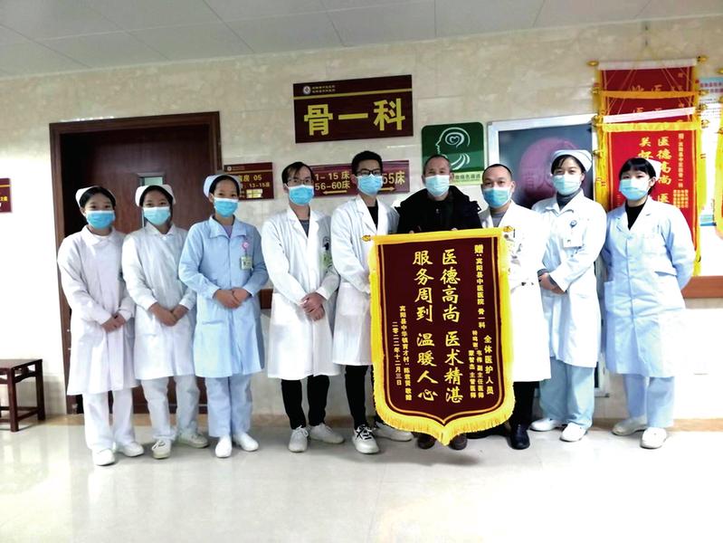 康复患者(中)给医疗团队送锦旗表示感谢(医院供图)■本报记者冯源