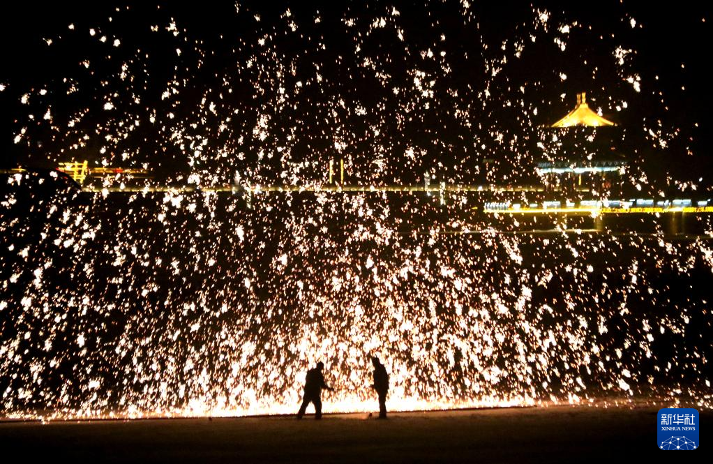 2月21日,在敦煌市党河风情线,民间艺人进行打铁花民俗表演.