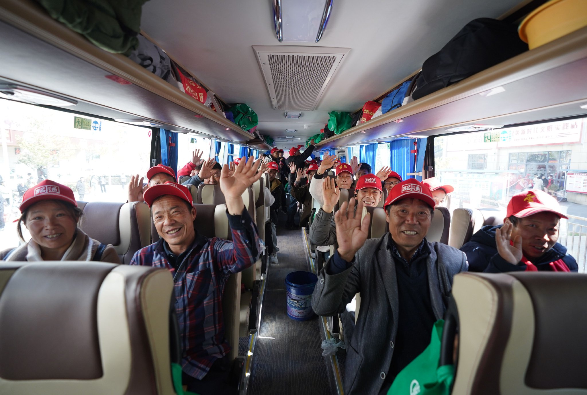 2月21日,在云南省昭通市的务工人员免费乘坐返岗直通大巴车前往福建