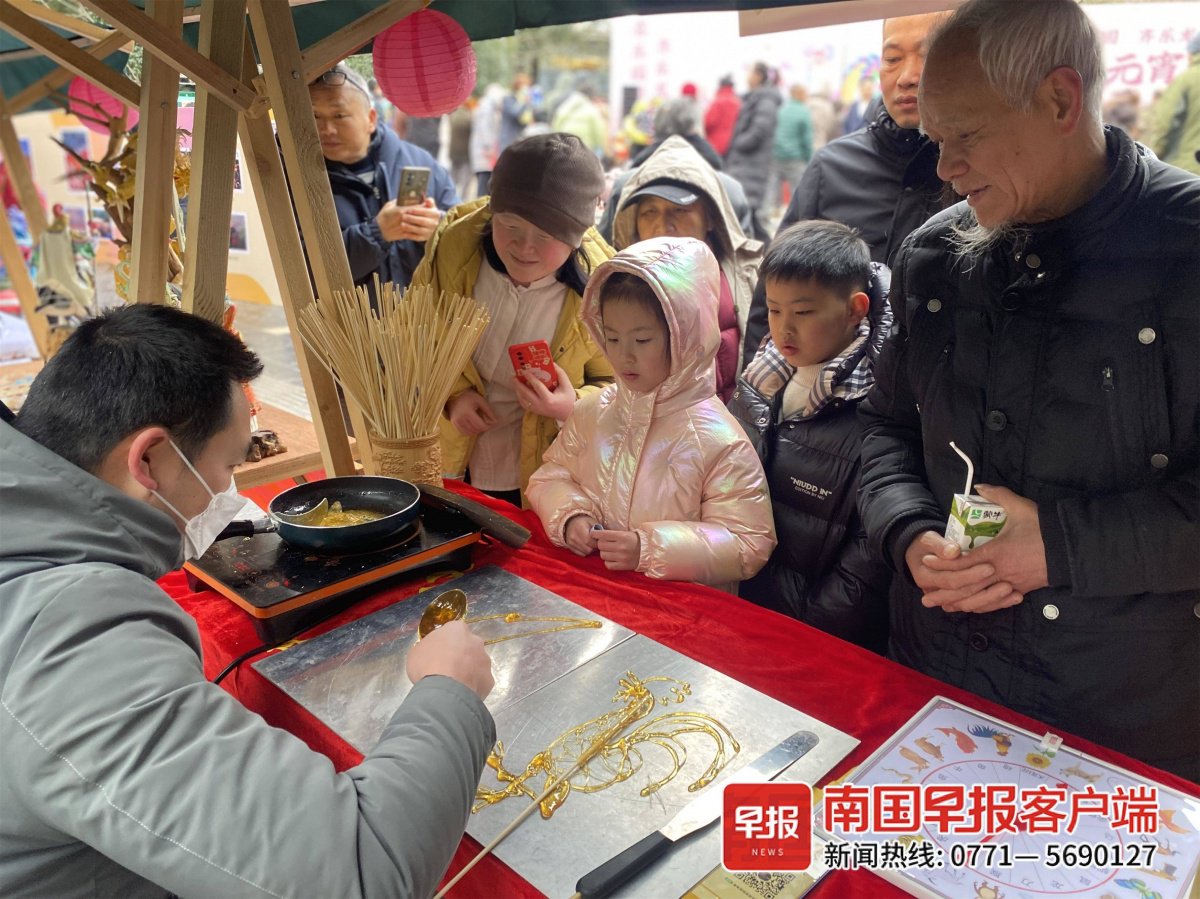 糖画摊位前,许多市民游客驻足观赏.