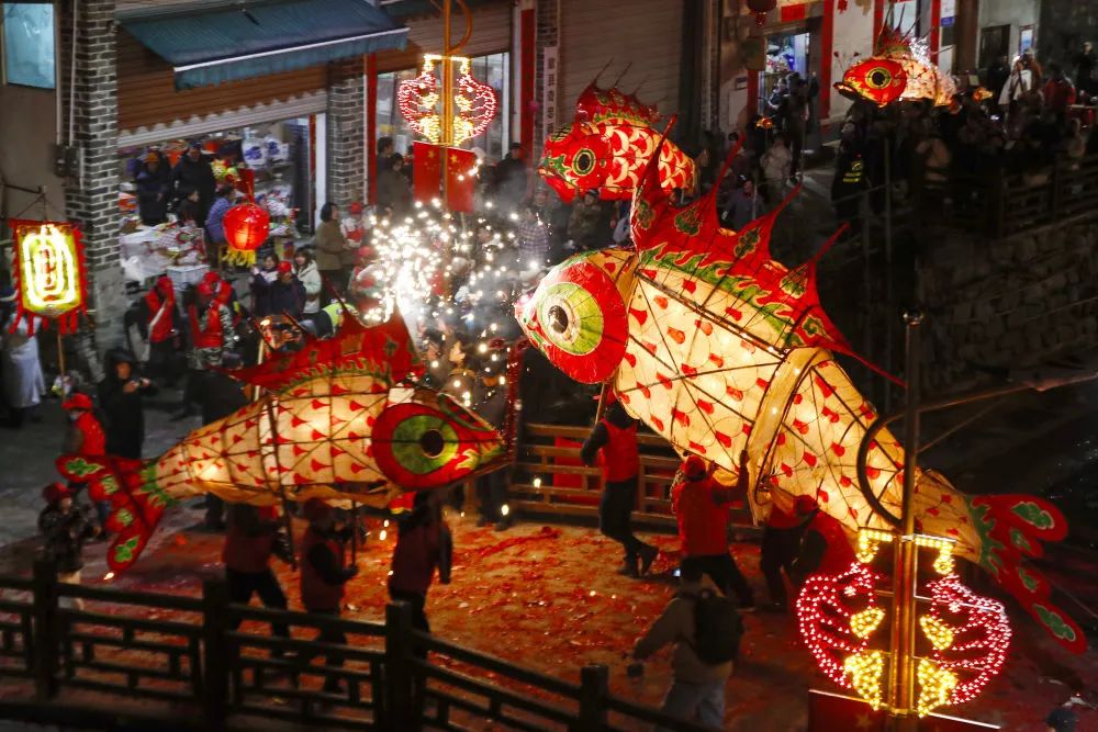 2月22日,在安徽省黄山市歙县溪头镇汪满田村,鱼灯表演队伍在村中嬉游