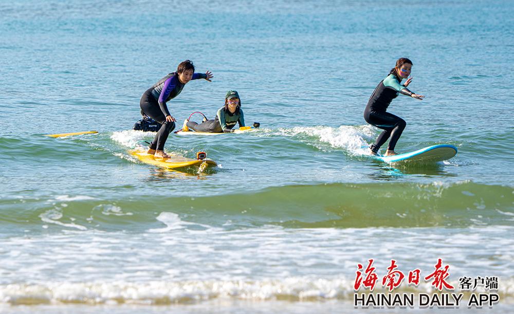 三亚后海,游客踩着冲浪板滑行.海南日报记者 袁琛 摄