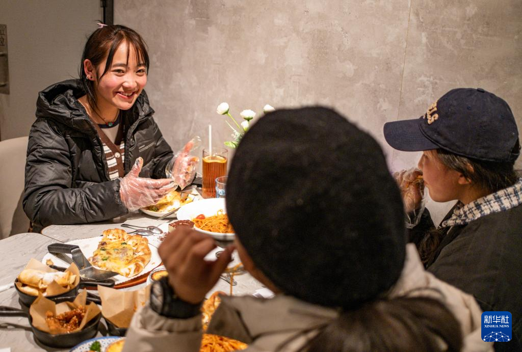 在拉萨市的一家必胜客餐厅,丹增和小姐妹们一起吃饭(2024年1月27日摄)