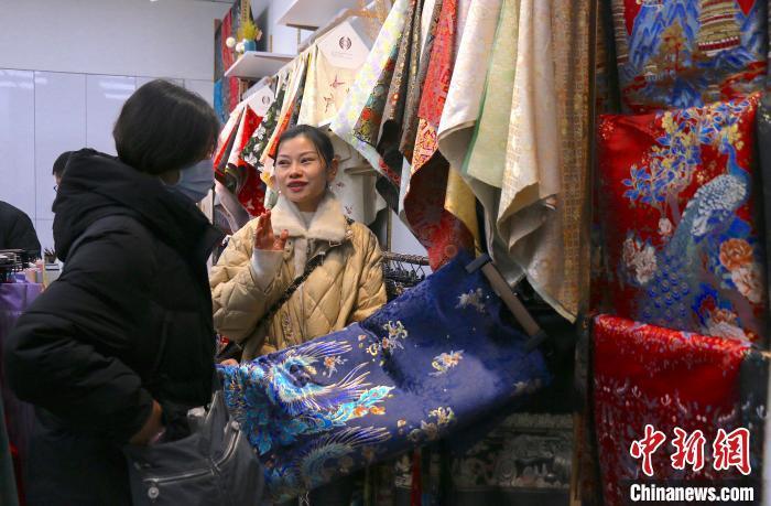 近日，中国轻纺城商家（左二）与客户洽谈马面裙面料生意。项菁 摄