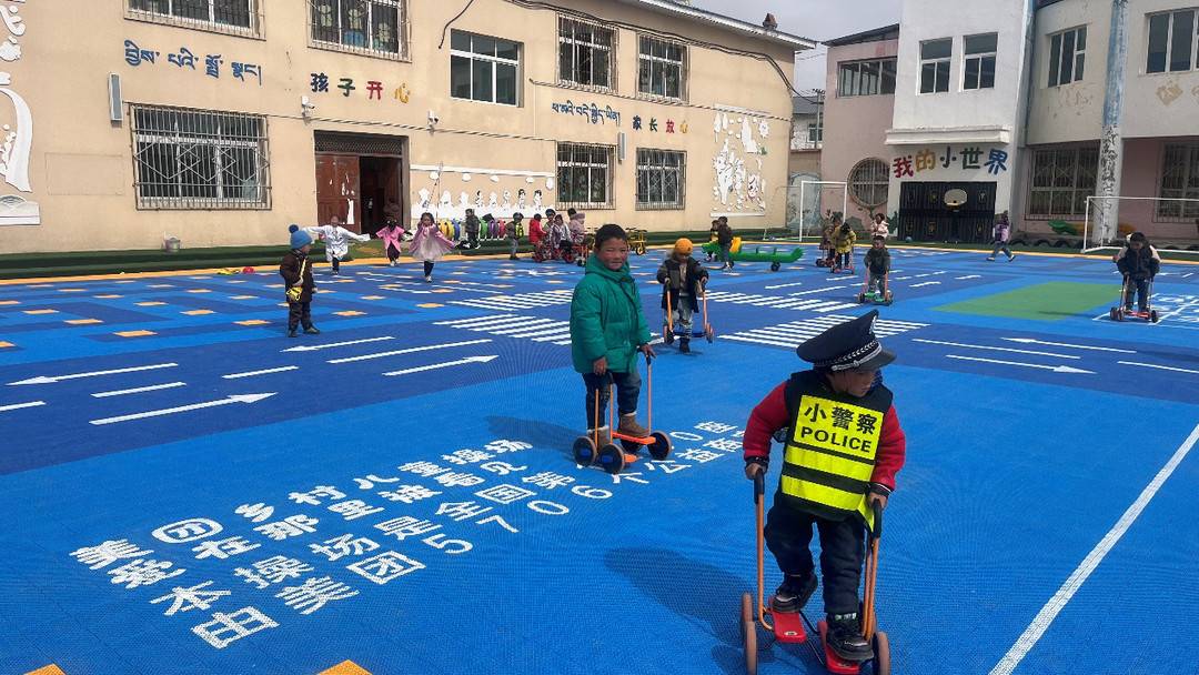 ▲ 若尔盖县唐克镇幼儿园的孩子们在乡村儿童操场上蹬踩步车（摄/扎西更忠）