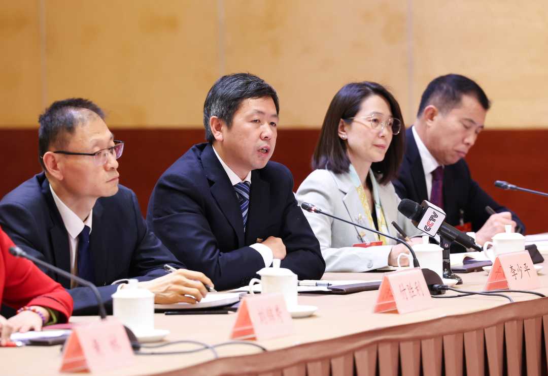 李少平代表（左二）在回答经济日报记者提问。经济日报记者　高兴贵摄