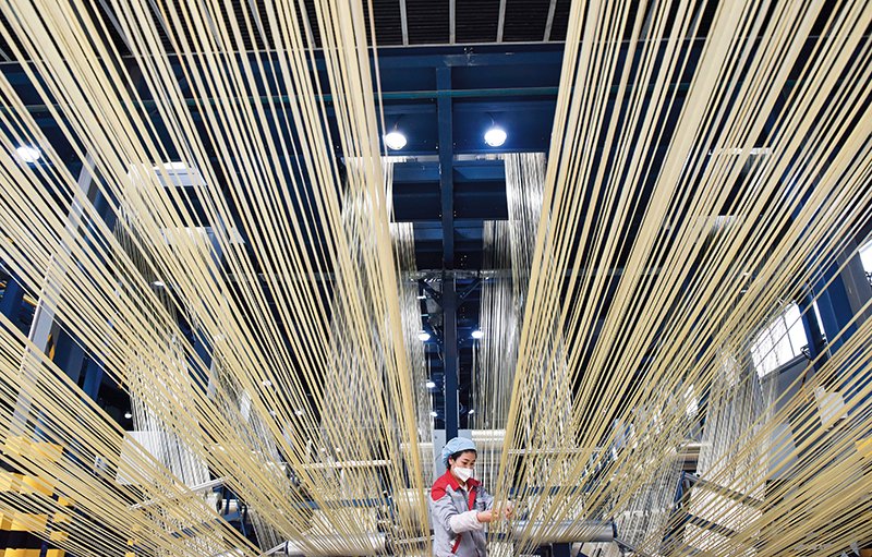在中复神鹰碳纤维西宁有限公司，工作人员在整理碳纤维原丝（2023 年2 月22 日摄） 吴刚摄/ 本刊