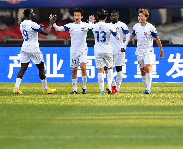 3月9日,梅州客家队球员康拉德(右二)进球后与队友庆祝.