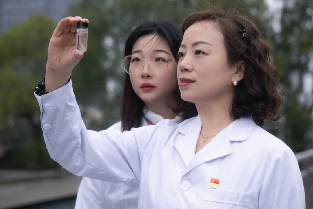 图为王琼(右)与同事在武汉宗关水厂对水样进行观察.