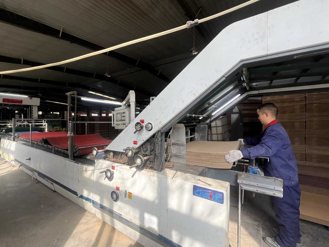 车间工人正在绿色印刷生产线上进行双层裱纸.刘国栋摄