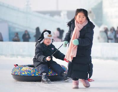 游客在哈尔滨冰雪大世界园区内玩雪圈。新华社记者 王建威摄