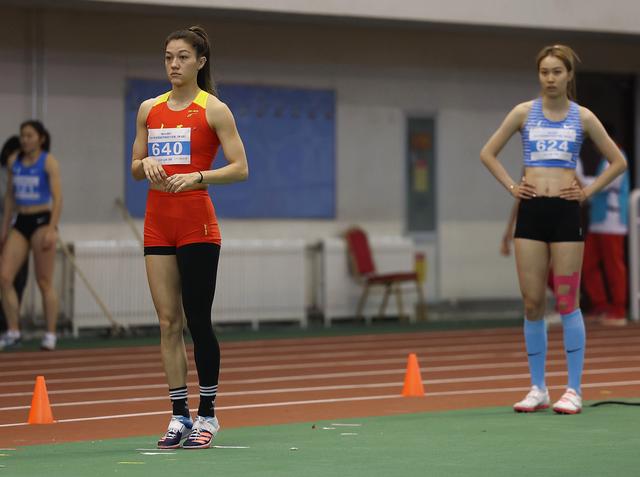 3月12日,山西选手郑妮娜力(左)在女子跳高决赛中准备试跳.