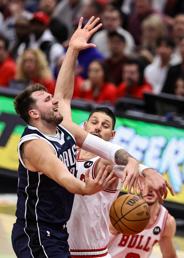 3月11日,公牛队球员武切维奇(前右)在比赛中防守独行侠队球员东契奇.