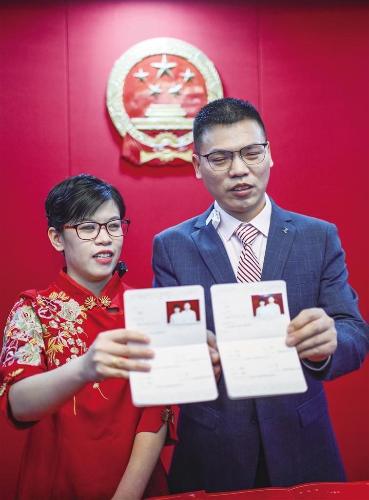 3月12日,新人张女士和王先生展示结婚证. 新华社记者 陈晔华 摄
