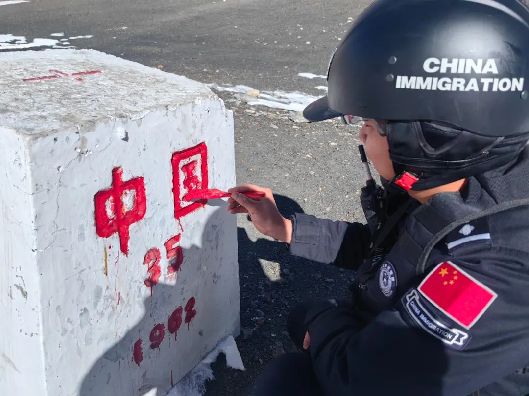 移民管理警察为界碑描红.