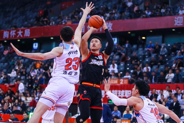 3月14日，深圳马可波罗队球员贺希宁（上右）在比赛中投篮。 新华社发（彭志刚摄）