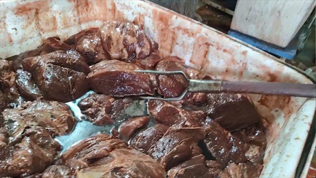 长丰镇西杨屯村一家煮肉作坊内，工人正在腌制假驴肉，其原料多为母猪前腿肉。新京报记者 韩福涛 摄