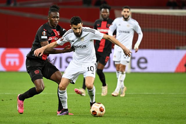 3月14日,勒沃库森队球员奥迪隆(前左)与卡拉巴赫队球员祖比尔(前右)在