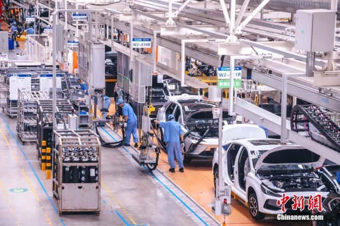 图为上汽集团宁德基地总装车间内,工人在新能源汽车生产线上作业.