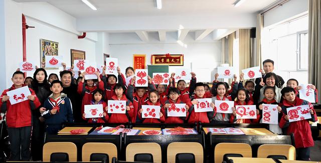 3月14日,段建珺(前左四)在和林格尔县第二小学与小学生合影.