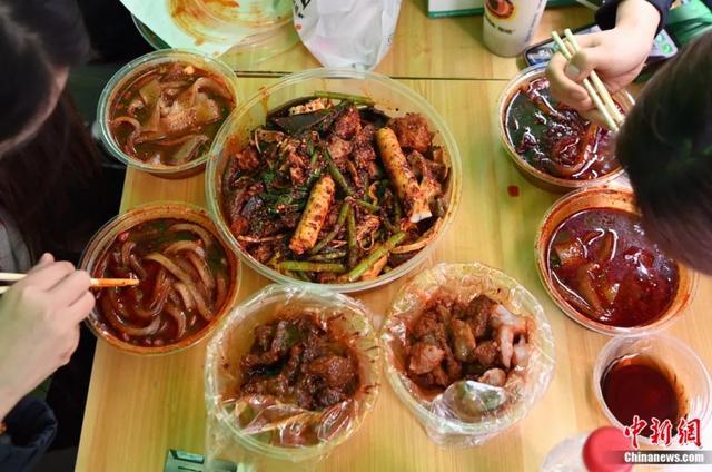 3月14日，甘肃天水，游客品尝麻辣烫。近日，甘肃天水麻辣烫在网络平台火爆，吸引全国各地众多游客前来品尝。九美旦增 摄