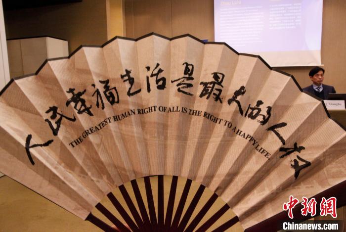 　　图为会议纪念品中国折扇，上写“人民幸福生活是最大的人权”。　中新社记者 德永健 摄