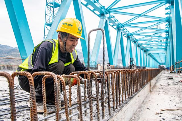 3月16日,工人在渝湘高铁清水坪乌江特大桥建设现场施工作业.