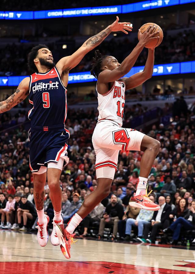 3月16日,公牛队球员多苏穆(右)在比赛中运球上篮.