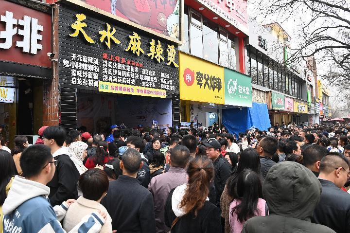 3月16日,在天水市秦州区的天水名优小吃城,游客排队等待品尝麻辣烫.