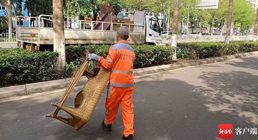 环卫工人清运临时堆放的大件家具。 记者 王康景 摄