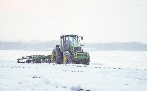      近日，“大粮仓”黑龙江垦区各地春耕备耕工作有序进行。图为大马力拖拉机对耕地进行耙雪除冰作业，促进冰雪融化。 新华社