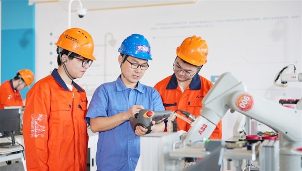 教师指导学生进行工业机器人应用编程.