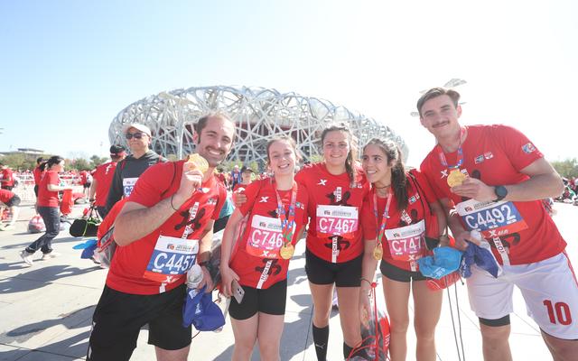 国际长跑节—北京半程马拉松落幕,完赛的外国选手在"鸟巢"前合影留念