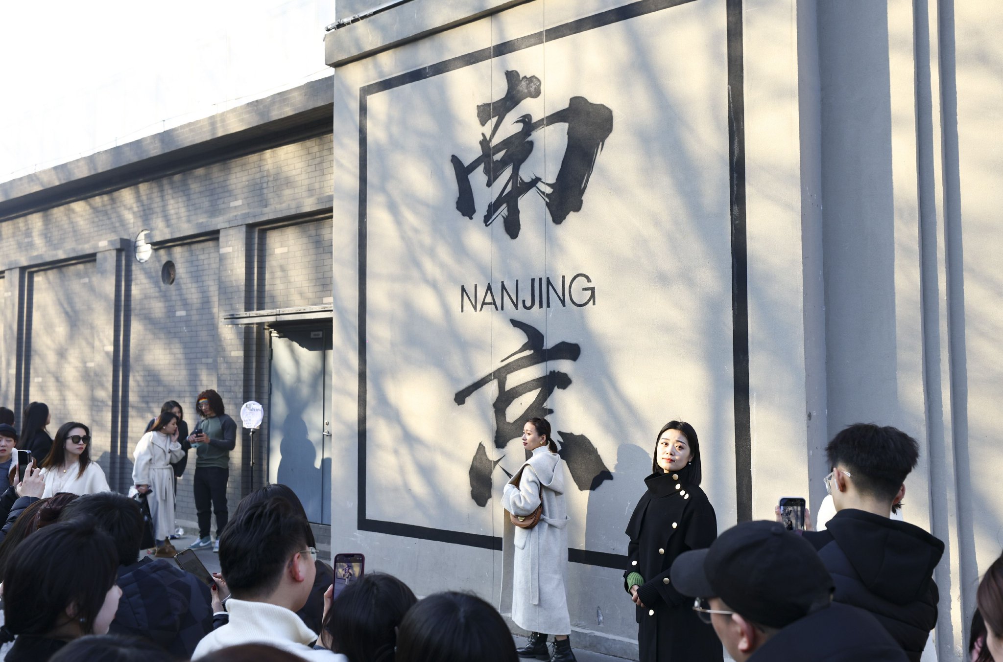 "3月的一天中午,阳光明媚,一群市民络绎不绝地在一面写有"南京"两个字