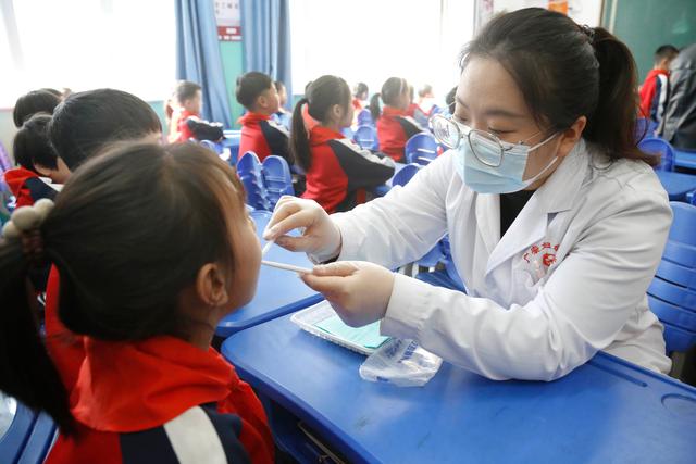 3月20日,河北省邢台市广宗县妇幼中心医护人员在给学生做口腔检查.