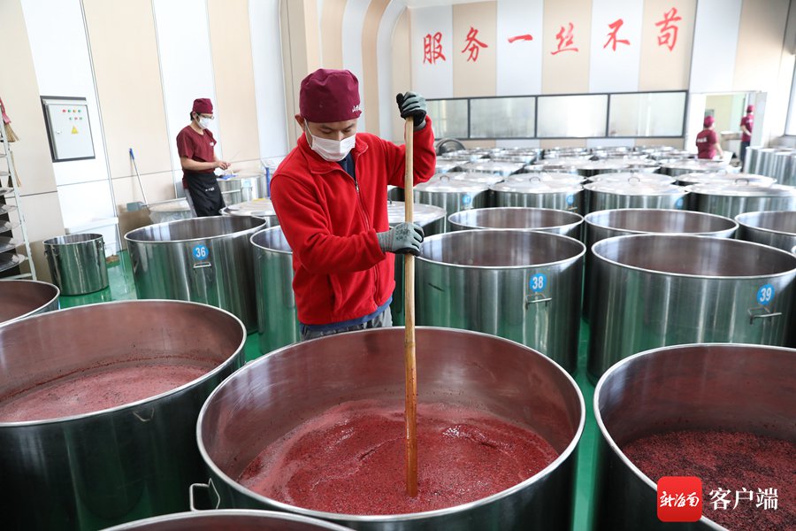 酿酒师傅为正在发酵的山兰酒开耙.记者 李庆芳 摄