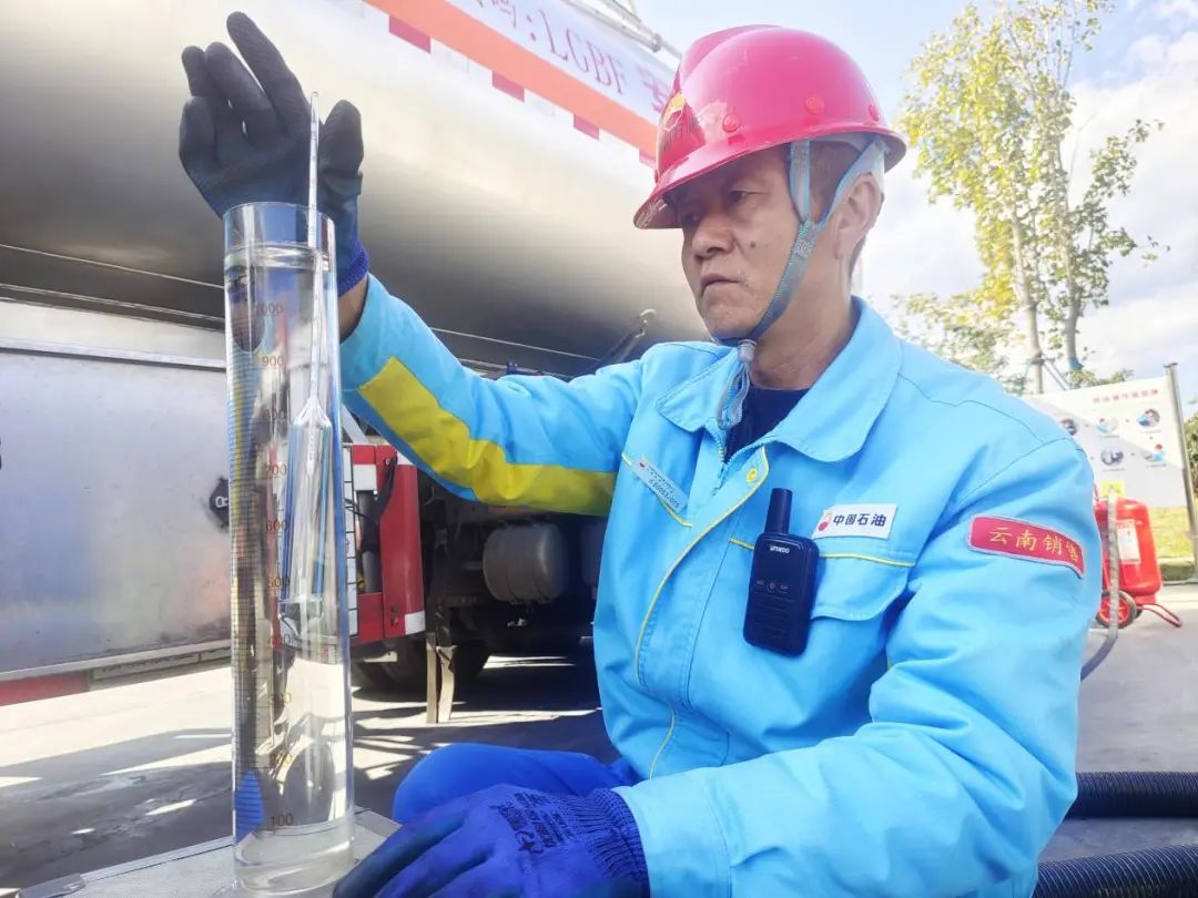 云南销售楚雄分公司牟定西加油站员工正在进行油品接卸,测量92号汽油
