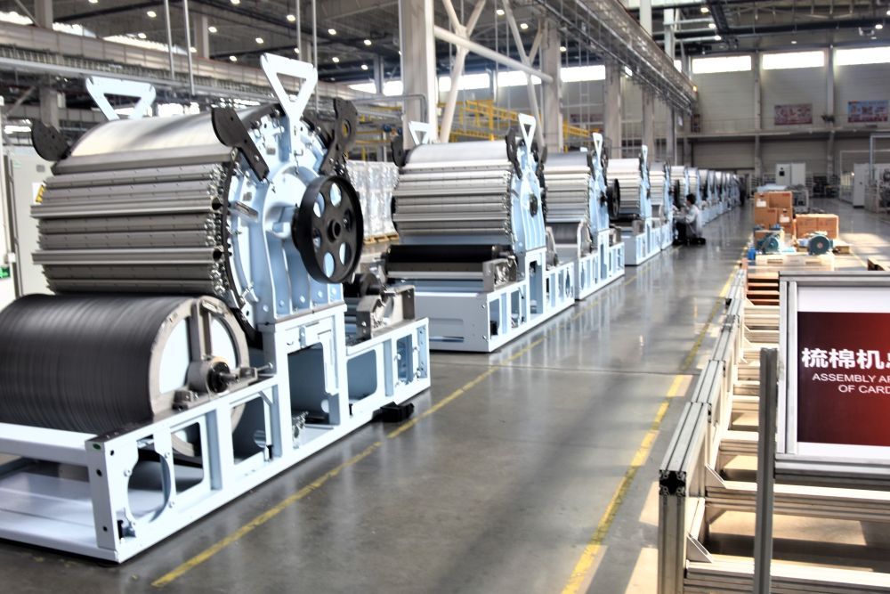 在卓郎新疆智能机械有限公司总装车间里，一台台梳棉机正待装配完成（2024年2月27日摄）。新华社记者 潘莹 摄