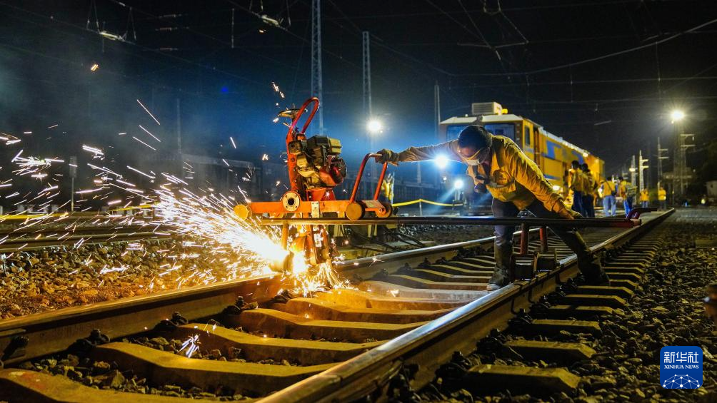 3月21日,在玉林至铁山港铁路线上,工人在打磨铁轨.