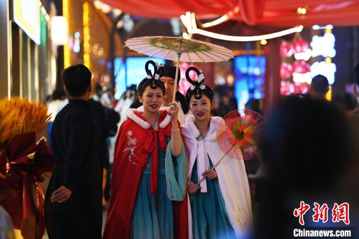 　　3月22日晚，甘肃省兰州市黄河食渡文旅美食街内，街区人员着传统服饰游园。李亚龙 摄