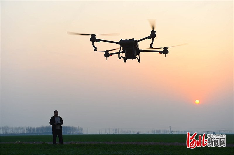 3月21日,宁晋县智琪家庭农场农民操控植保无人机准备为麦田洒农药.