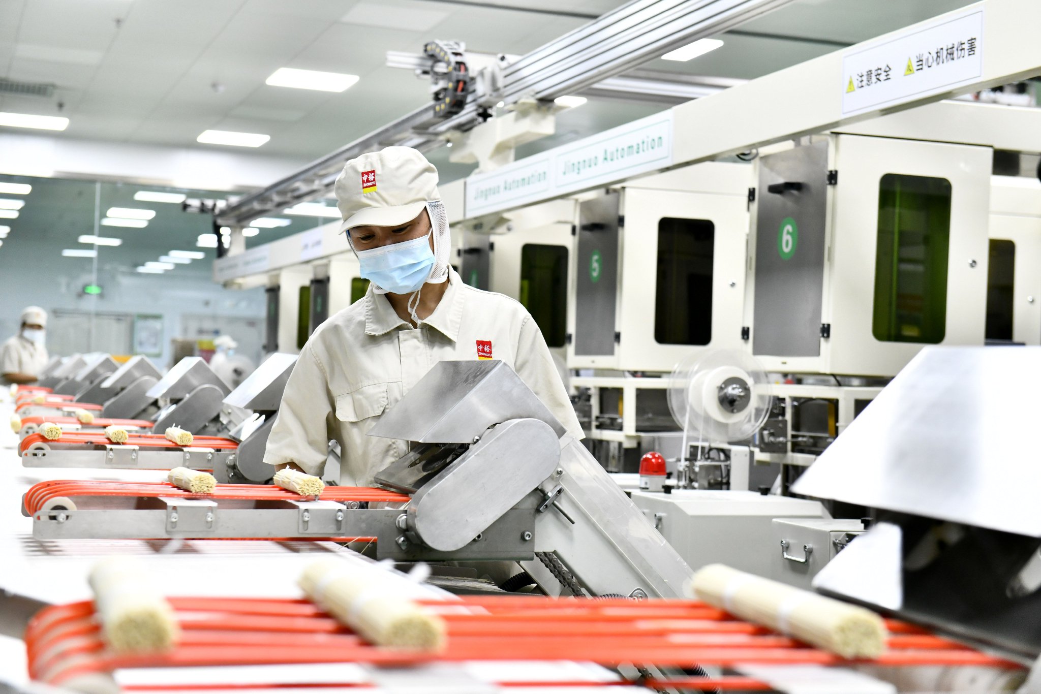 在滨州中裕食品有限公司挂面生产车间,工作人员在流水线上值守.