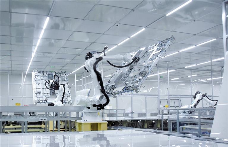 3月20日，在G8.5+基板玻璃生产线项目生产车间，工业机器人在进行相关作业。 记者 张乐佳摄