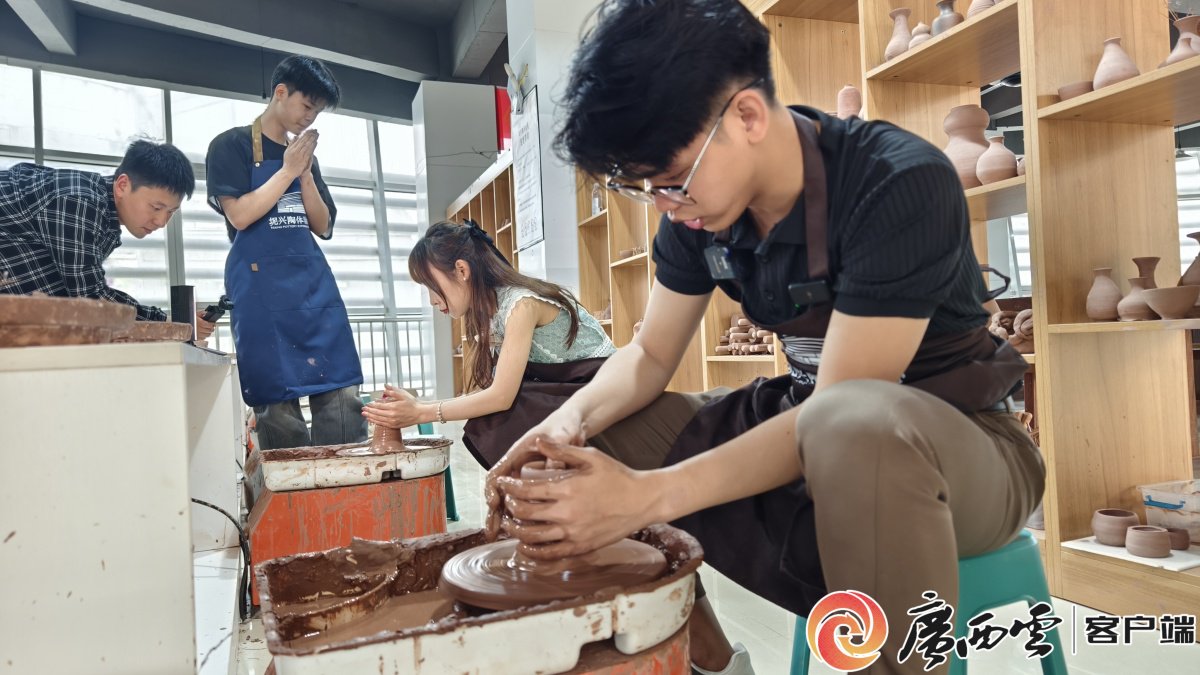 图为采风团成员在钦州坭兴陶体验中心体验制作陶器过程。