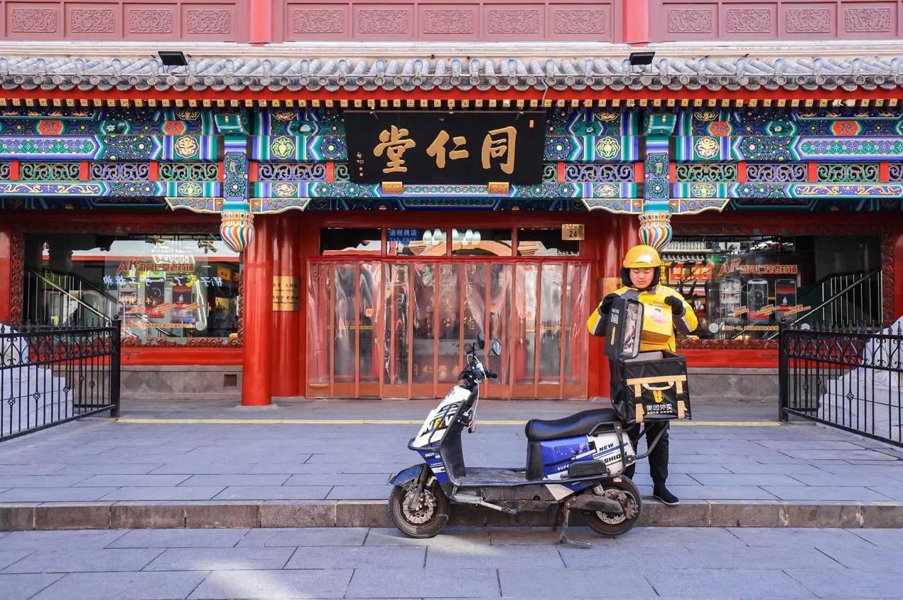 美团骑手在北京同仁堂大栅栏门店取货。 摄影 刘男
