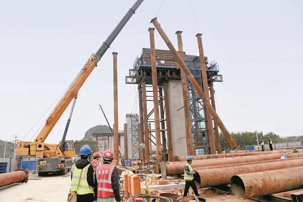 工人利用吊车吊装钢管支架.