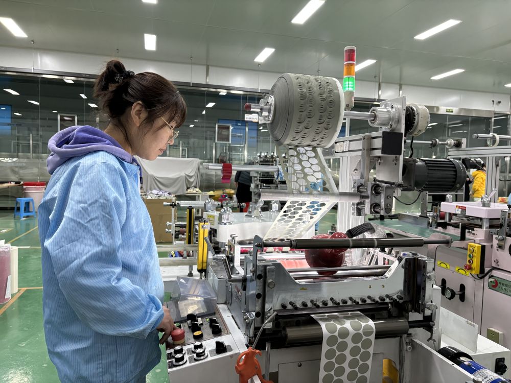 河北思瑞恩新材料科技有限公司生产车间内,工人正在操作全自动模切机.