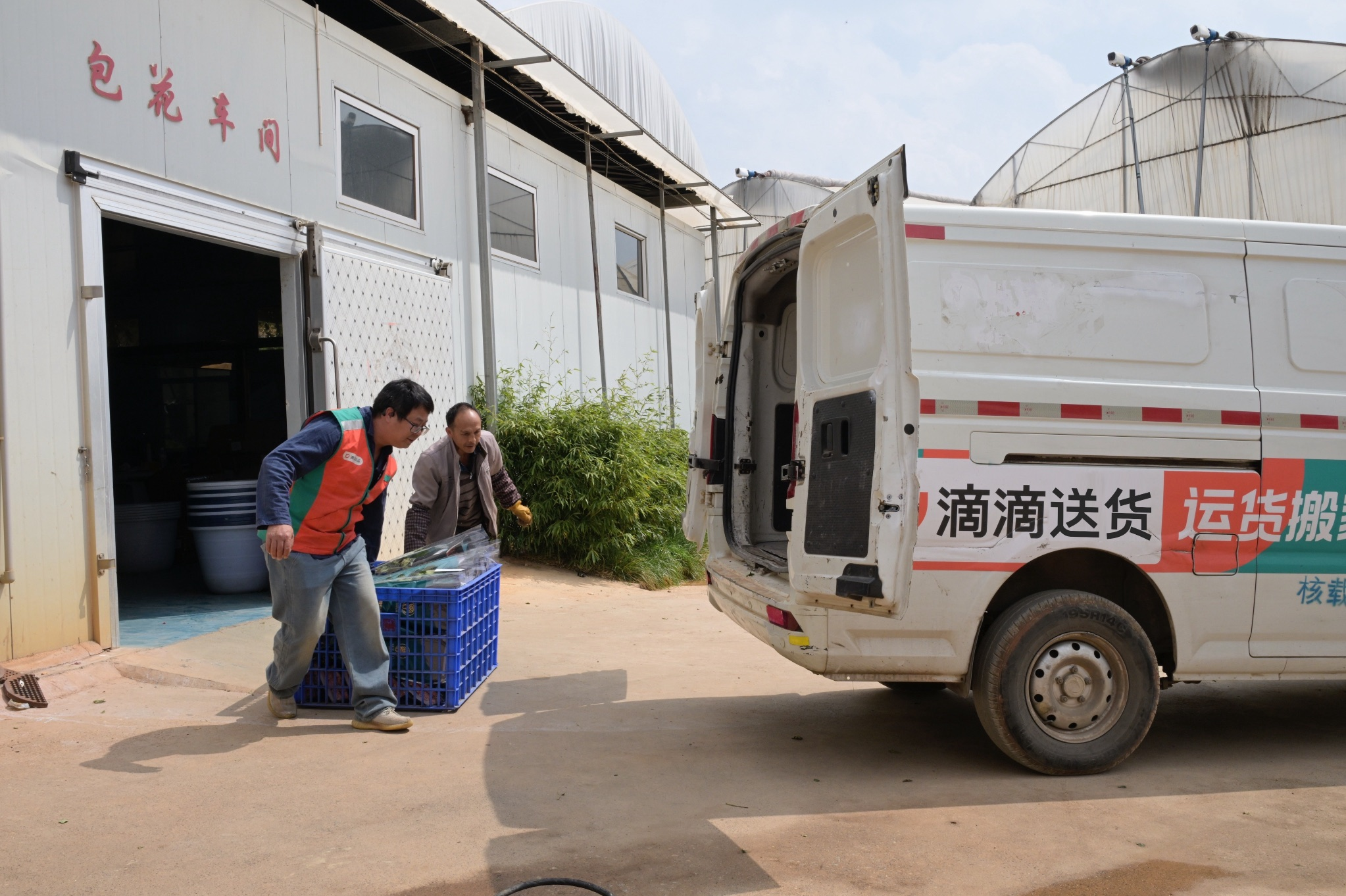 图：滴滴送货司机正帮商户把花搬上车。