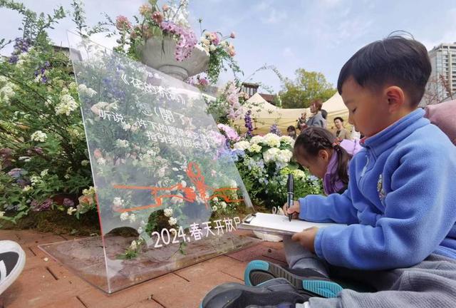 追梦园内，孩子们围坐在花坛旁绘画。 陈玺撼摄