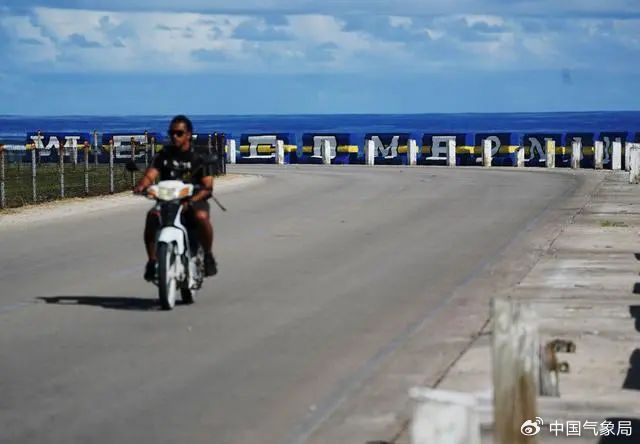 摩托车行驶在瑙鲁国际机场附近海边的公路上 图片来源：新华社